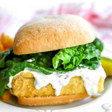 A vegan fish sandwich with vegan tartar sauce and lettuce.