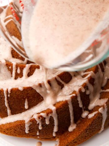 Pouring vegan icing over a vegan bundt cake.