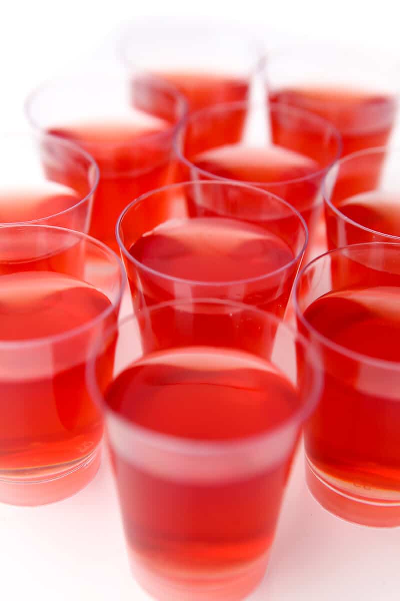 Little clear cups filled with red vegan jello shots.