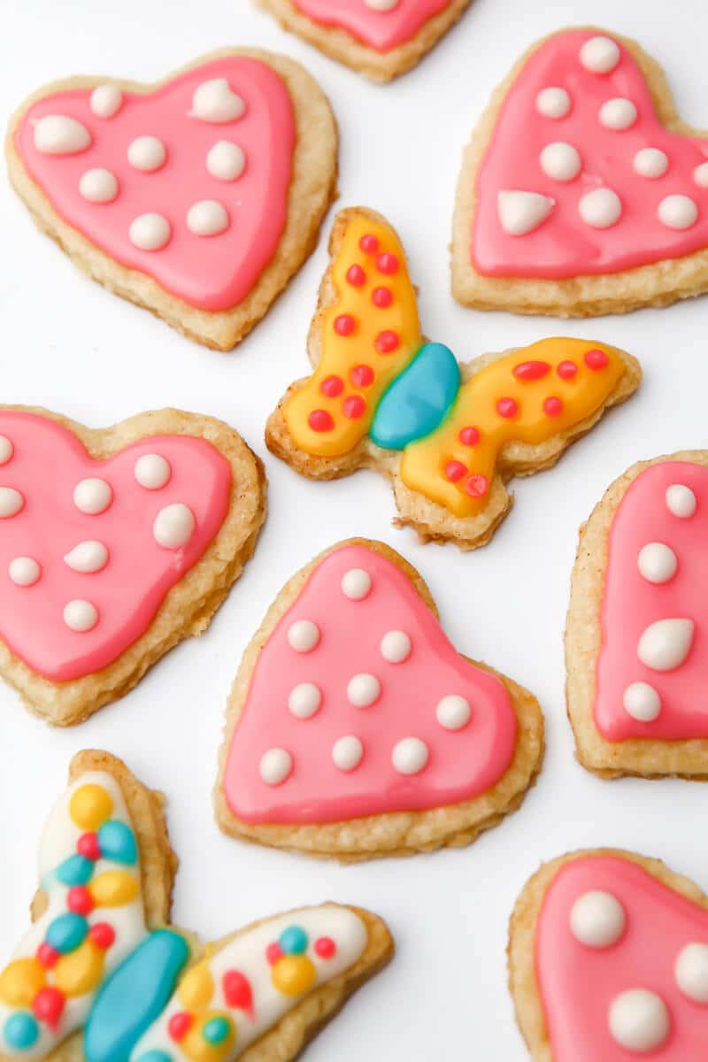 Vegan sugar cookies cut into hearts and butterflies and decorated with royal icing.