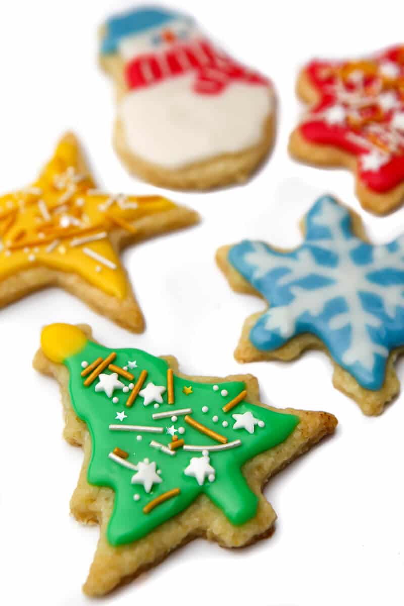 Vegan cut out cookies in Christmas shapes and decorated with brightly colored royal icing.