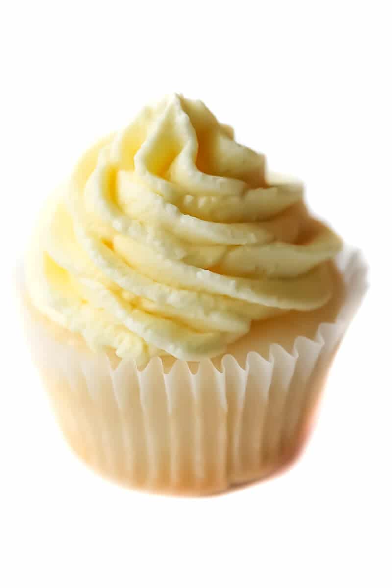 A cupcake topped with vegan lemon flavored buttercream frosting.