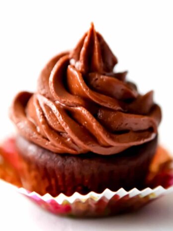 A chocolate cupcake topped with chocolate vegan buttercream.