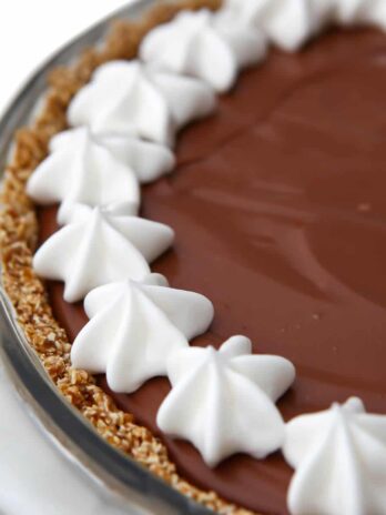 A vegan chocolate cream pie with a border of vegan whipped cream around the edge.