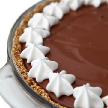 A vegan chocolate cream pie with a border of vegan whipped cream around the edge.