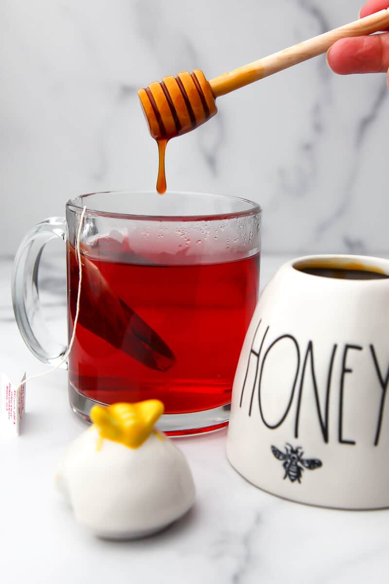 Vegan honey being drizzled into a cup of tea.