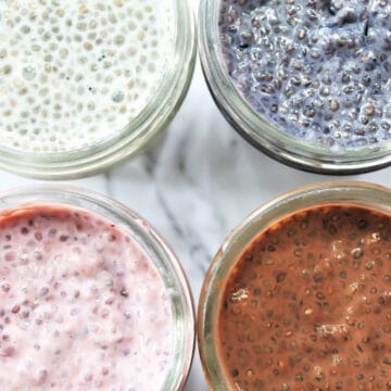 Strawberry, blueberry, vanilla, and chocolate chia seed puddings in mason jars.