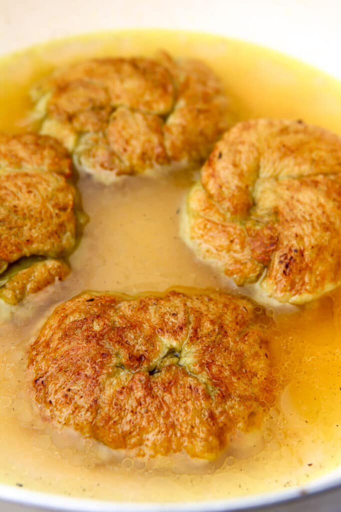 Knots of washed flour that has been seasoned and fried on both sides simmering in broth.