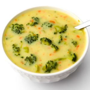 A top view of a white bowl filled with vegan cream of broccoli soup.