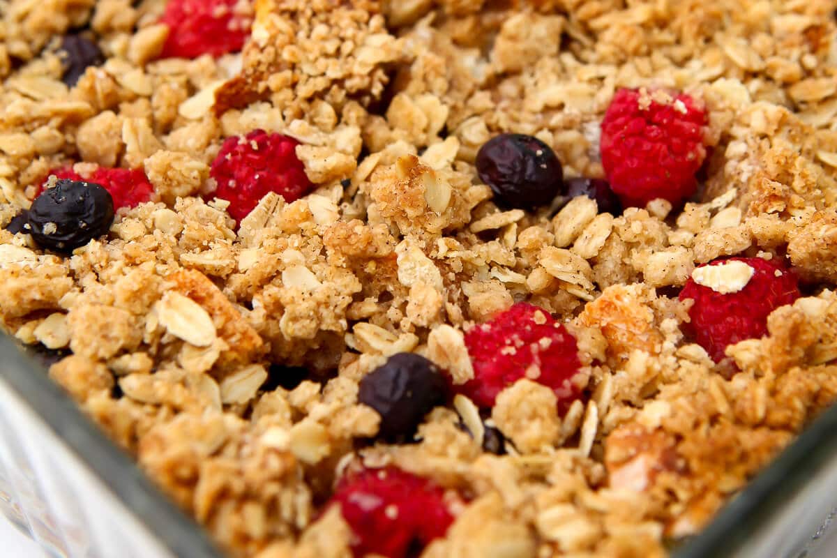 A close up of a baked vegan French toast casserole with crumble crust and berries.