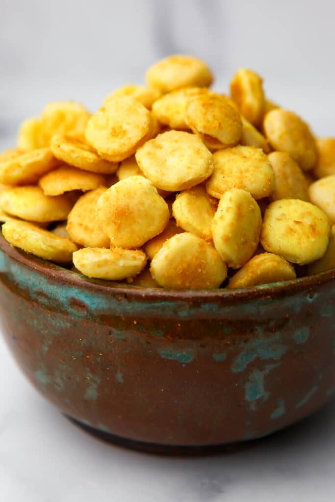 A close up of a bowl of seasoned oyster cracker made to taste like goldfish crackers.