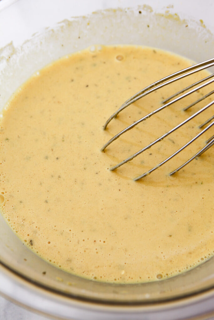 The wet ingredients for the chickpea egg muffins mixed in a glass bowl.