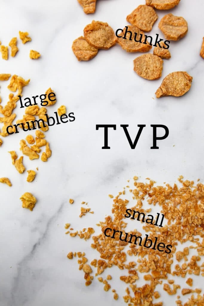 Three different sizes and shapes of TVP on a marble counter top showing chunks, large crumbles, and small crumbles.