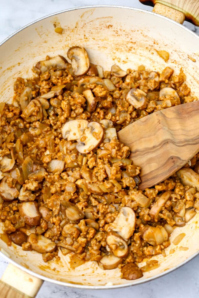 Vegan beef crumbles added to mushrooms and onions to make vegan beef stroganoff.