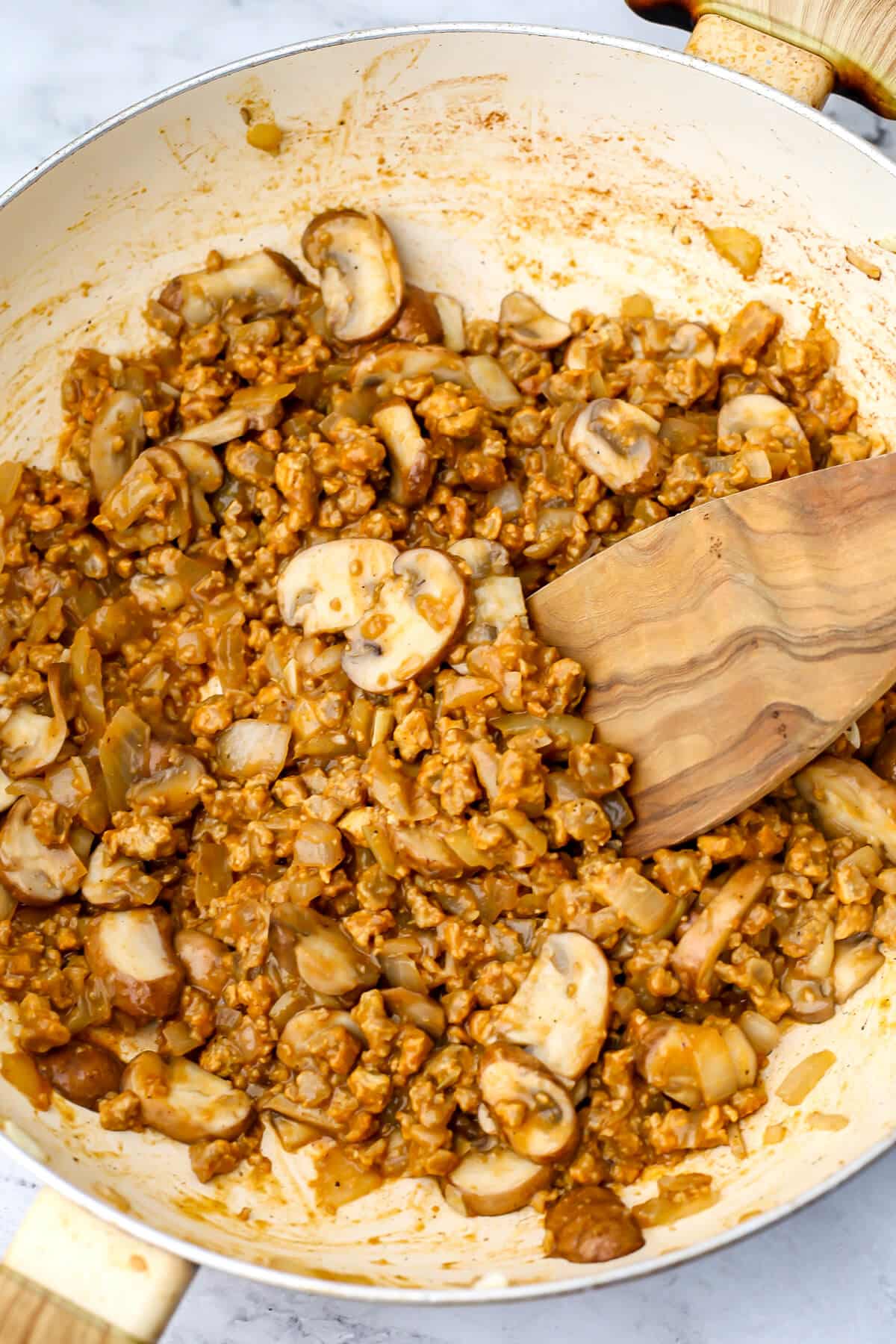 Vegan beef crumbles added to mushrooms and onions to make vegan beef stroganoff.