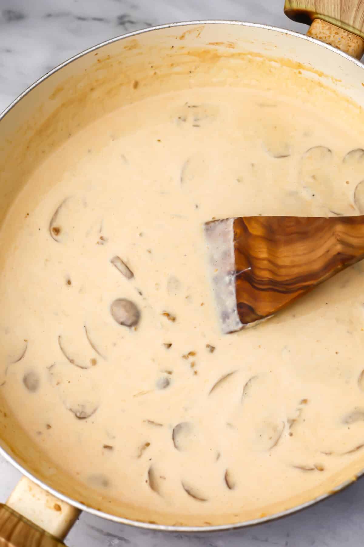 Stirring the vegan stroganoff sauce until creamy.