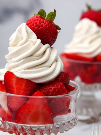 Vegan whipped cream frosting piped onto sliced strawberries.