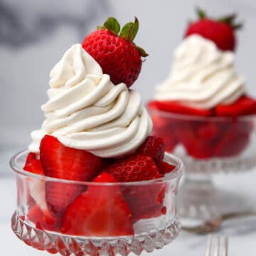 Vegan whipped cream frosting piped onto sliced strawberries.