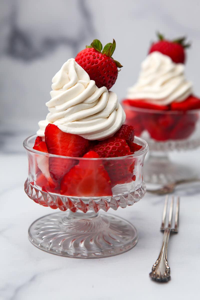 Vegan whipped cream frosting over strawberries.