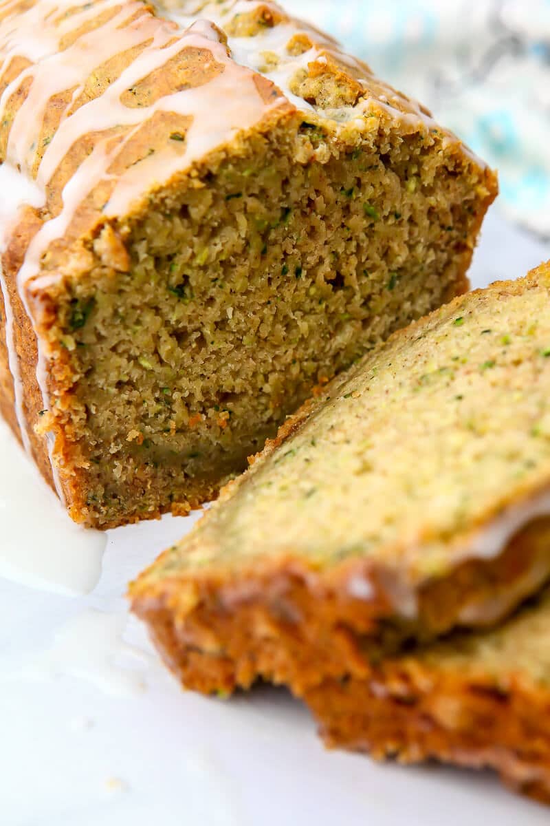 A close up of sliced vegan zucchini bread with lemon drizzle on top.