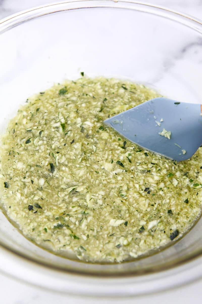 Shredded zucchini, sugar, oil, and egg replacer in a bowl to make vegan zucchini bread. 