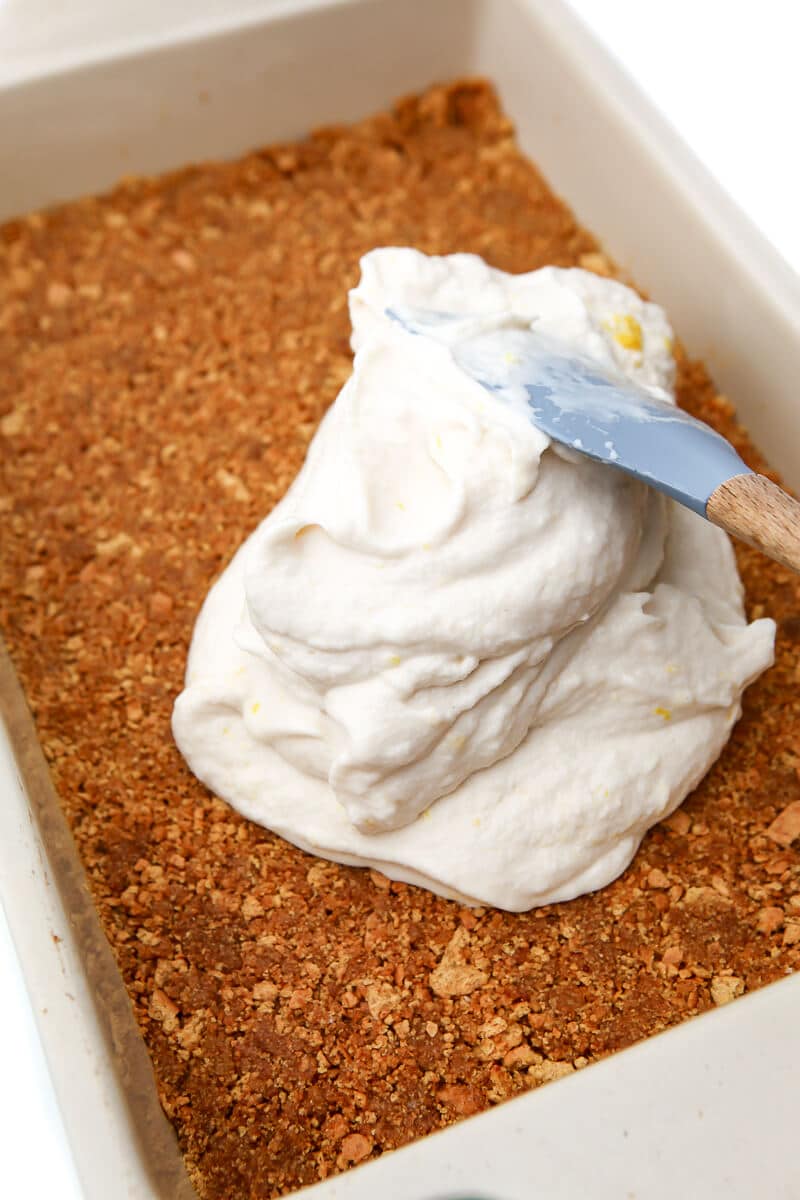 Blended vegan ice cream being spread onto a vegan graham cracker crust.