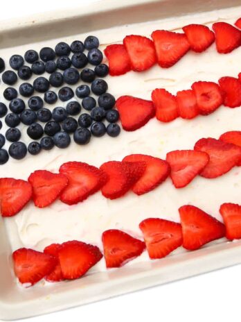 A vegan ice cream cake with blueberries and strawberries in the shape of an American flag on top.