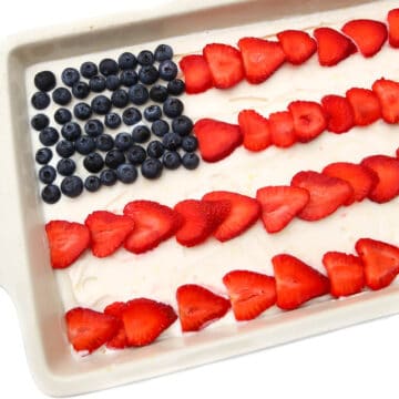 A vegan ice cream cake with blueberries and strawberries in the shape of an American flag on top.