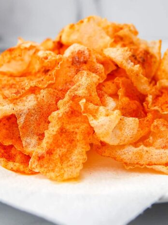 A pile of vegan pork rinds made with fried rice paper on a white plate.