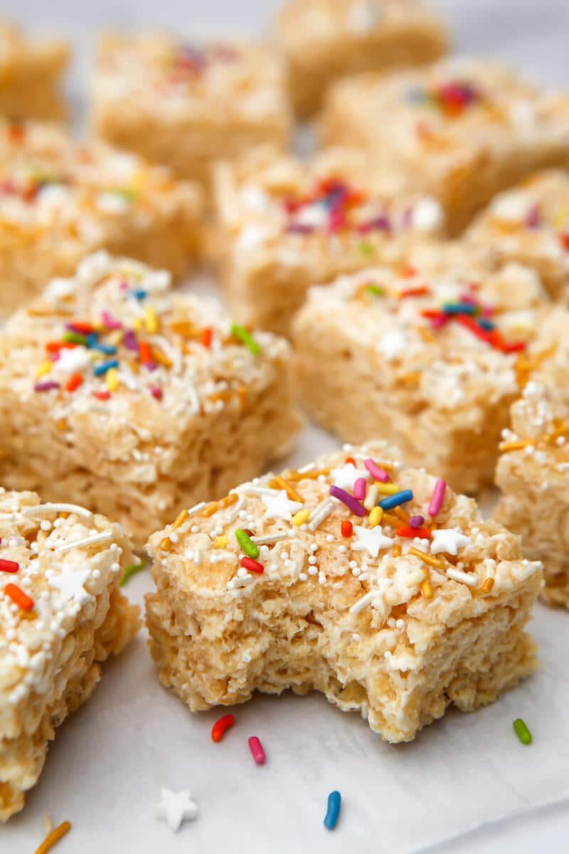 Vegan rice krispie treats cut into squares with a bite taken out of one.