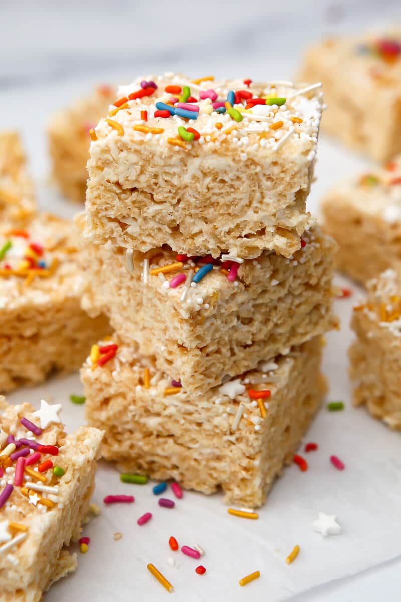 A stack of vegan rice krispie treats with colorful sprinkles on top.