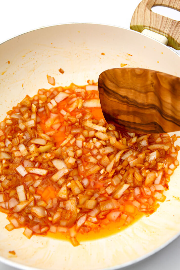 Onions sautéing with paprika for a vegan German potato salad recipe.