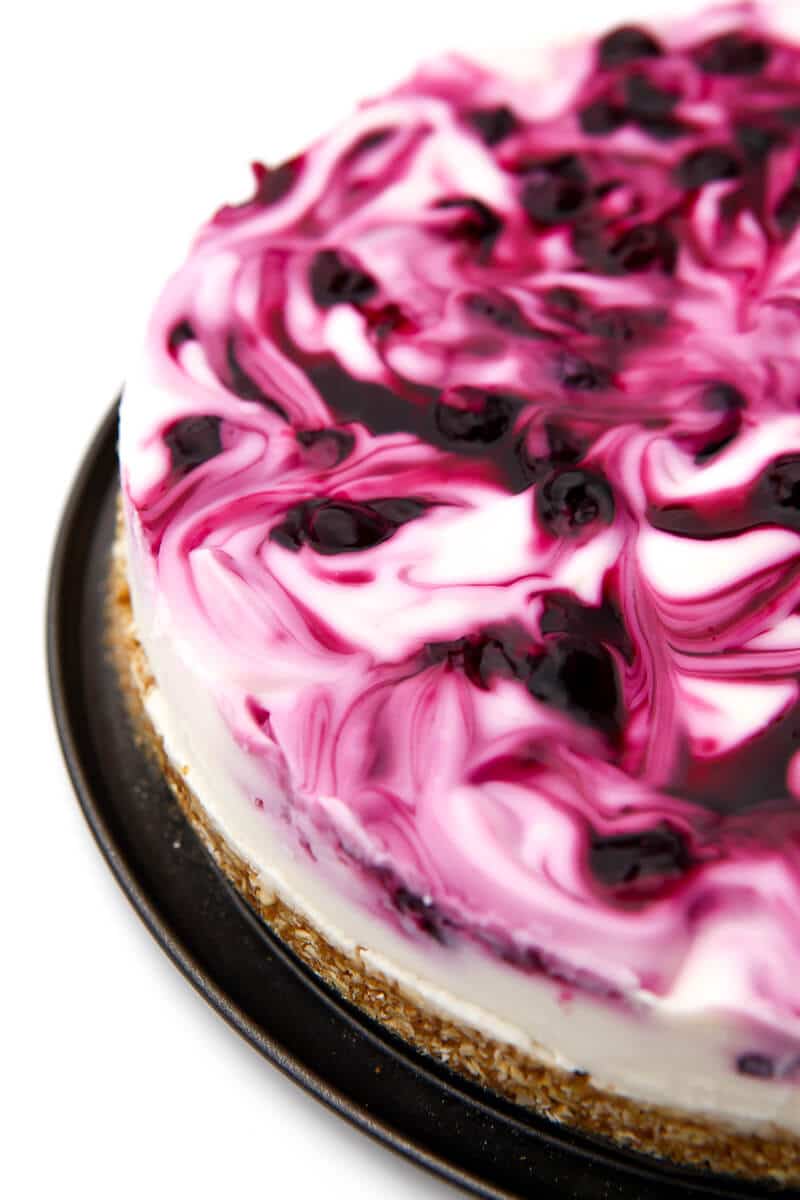 A no-bake vegan blueberry swirl cheesecake before it has been cut.