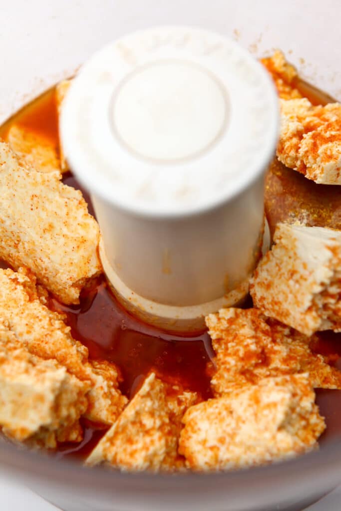 Tofu in a food processor with hot dog flavored broth before blending.