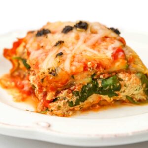 A slice of vegan zucchini lasagna on a white plate.
