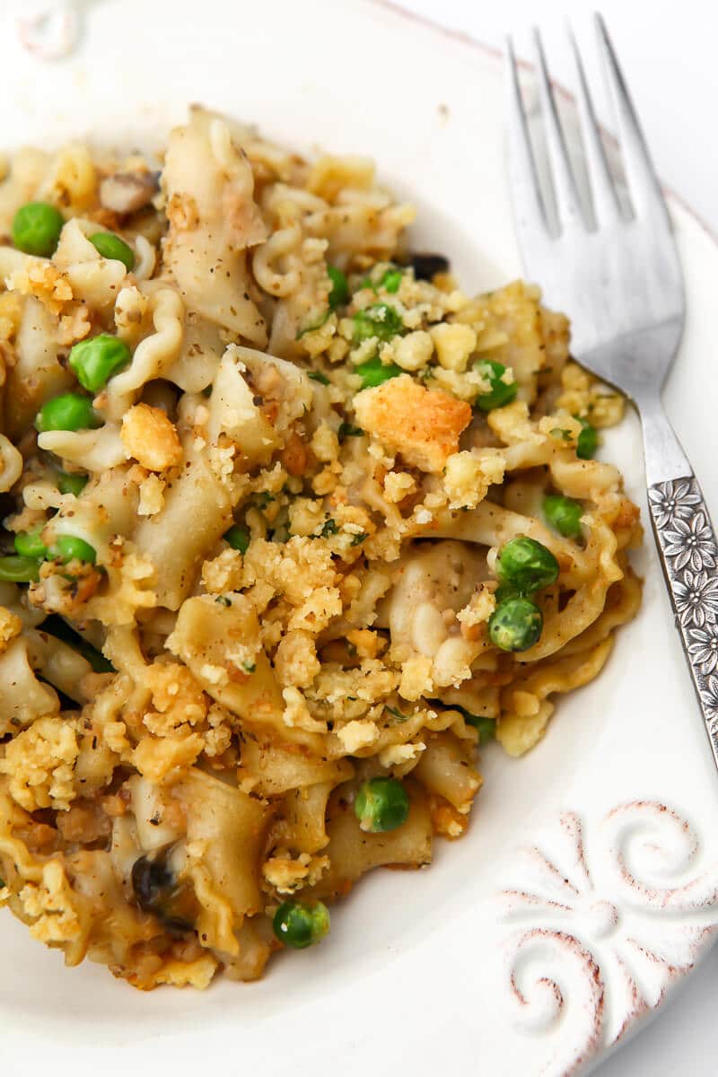 Vegan tuna noodle casserole on a white plate with a fork on the side.