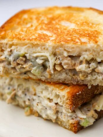 A close up of a vegan tuna sandwich on a white plate.