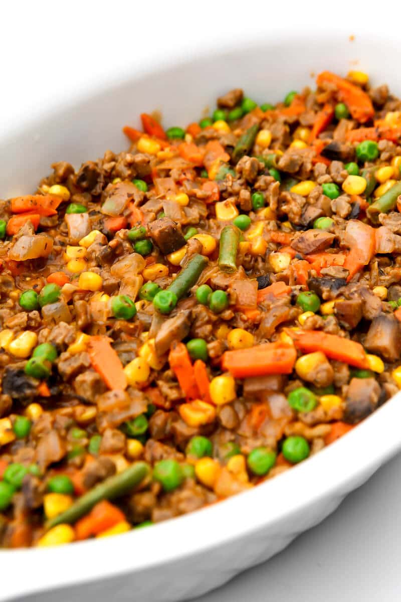 The base of a vegan shepherd's pie with vegan crumbles and mixed veggies.