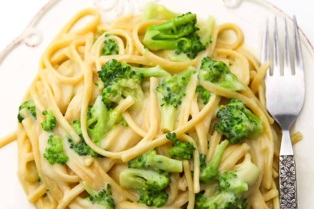 A top view of vegan alfredo with broccoli with a fork on the side.