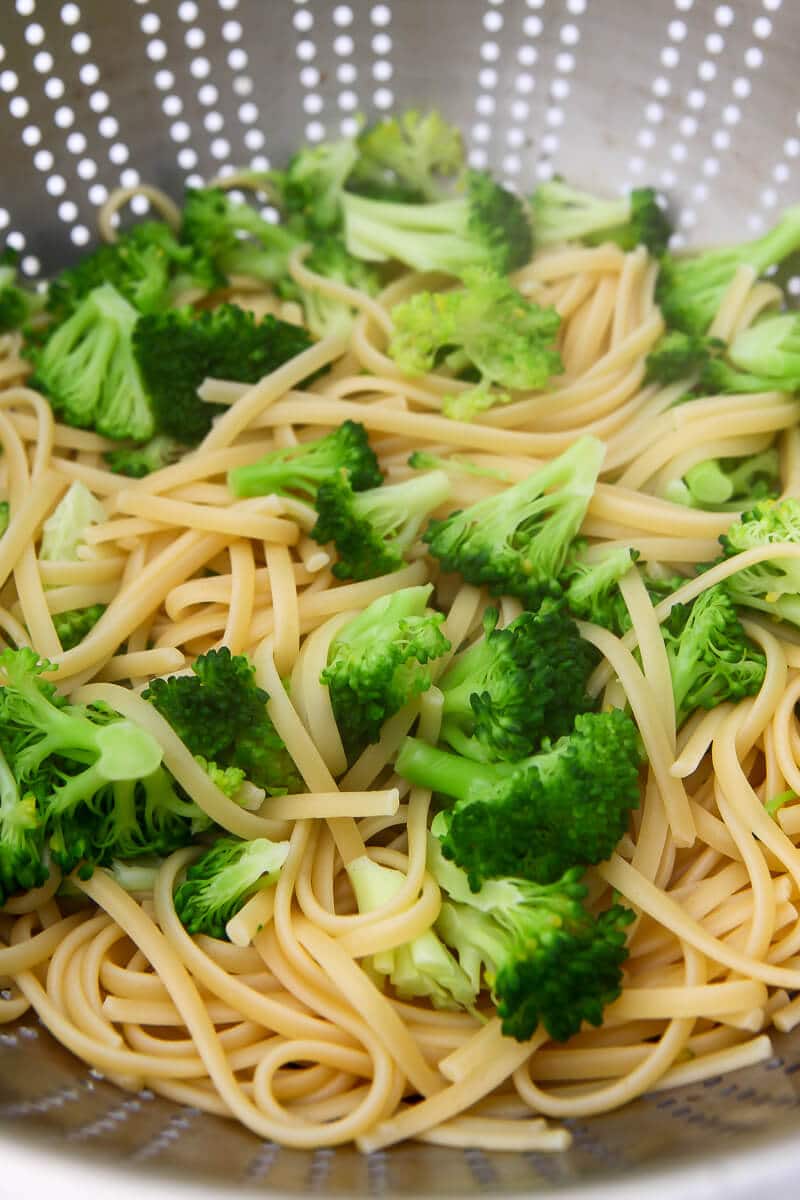 Cooked pasta and broccoli in a cullender.