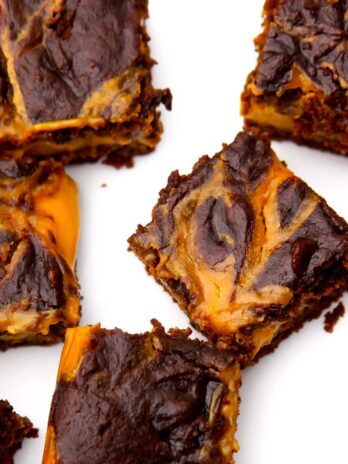 A top view of vegan pumpkin brownies with a pumpkin cheesecake swirl on the top.