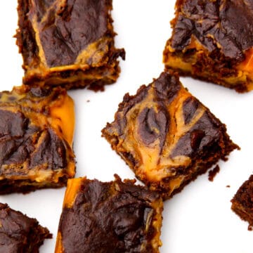 A top view of vegan pumpkin brownies with a pumpkin cheesecake swirl on the top.
