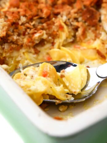 A close up of a vegan squash casserole using yellow squash and topped with a breadcrumb topping.