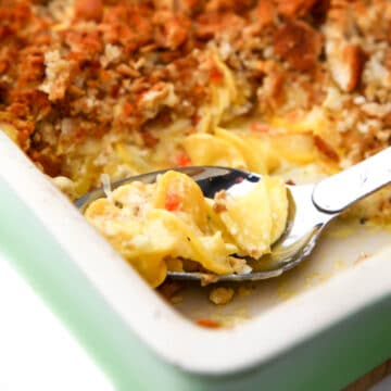 A close up of a vegan squash casserole using yellow squash and topped with a breadcrumb topping.