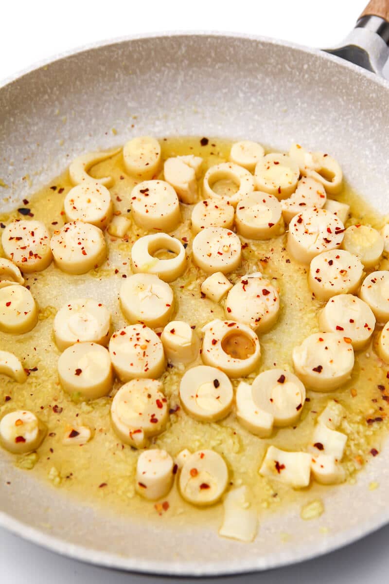 Hearts of palm cooking in a garlic butter sauce to make scampi.