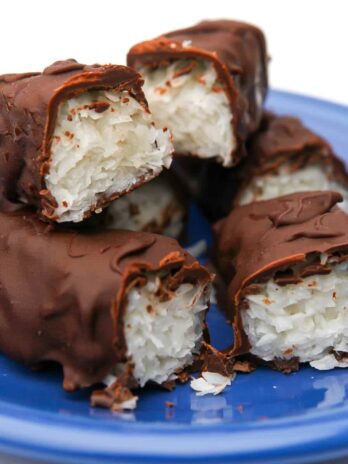 A pile of vegan Mounds bars that have been cut in half on a blue plate.
