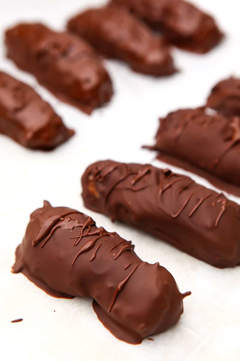 Homemade vegan Mounds and Almond Joy candy bars cooling on a piece of parchment paper.