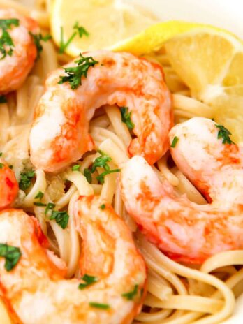 A close up of vegan shrimp scampi with a slice of lemon on the side.