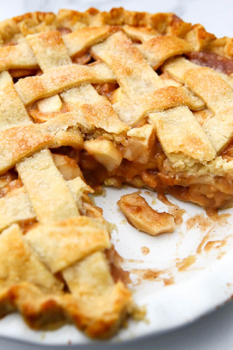 A vegan apple pie with a slice taken out of it.