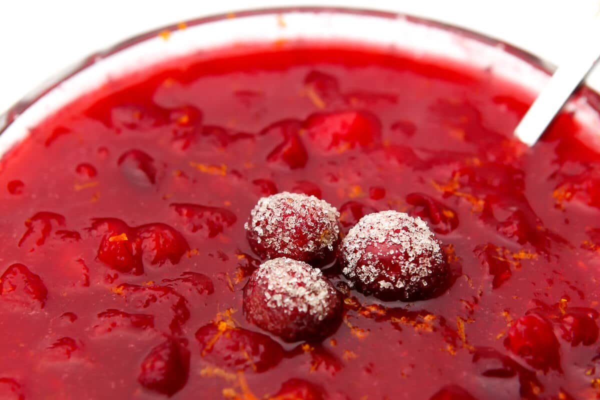 A close up of vegan cranberry sauce with sugared cranberries on top.